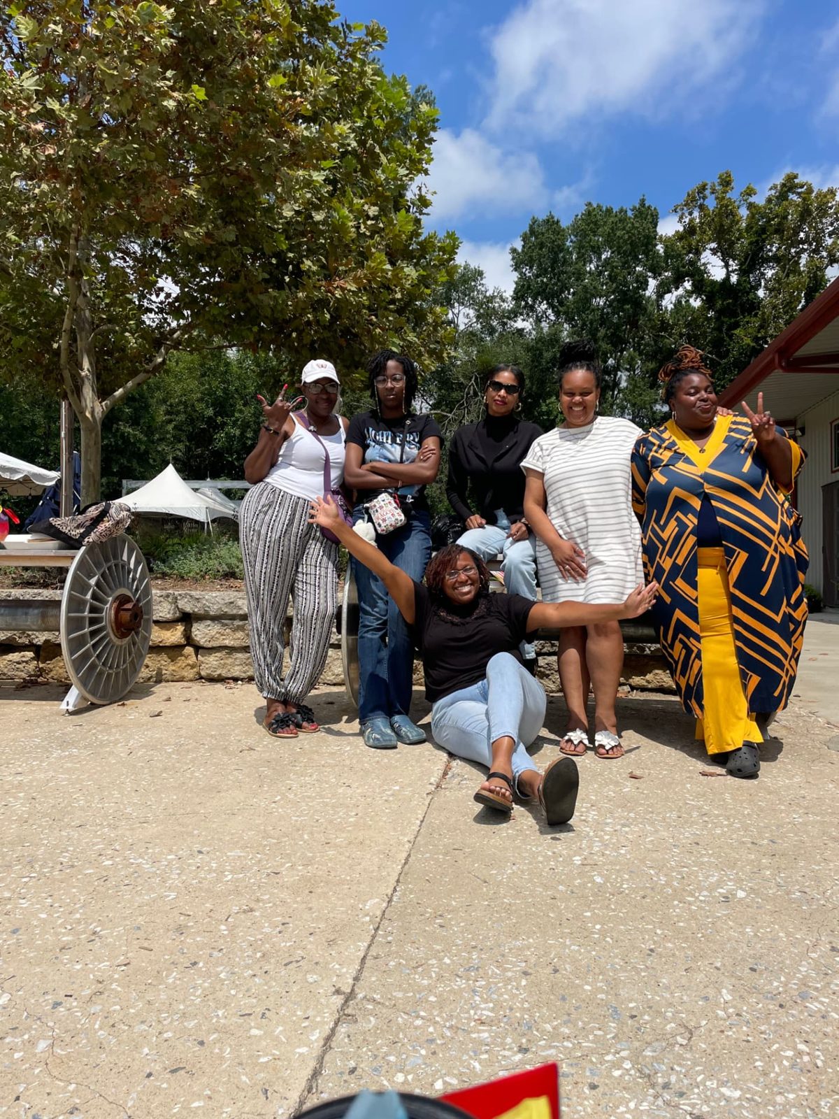Women of Daughters of the King gathered outdoors on a sunny day, laughing and posing together.